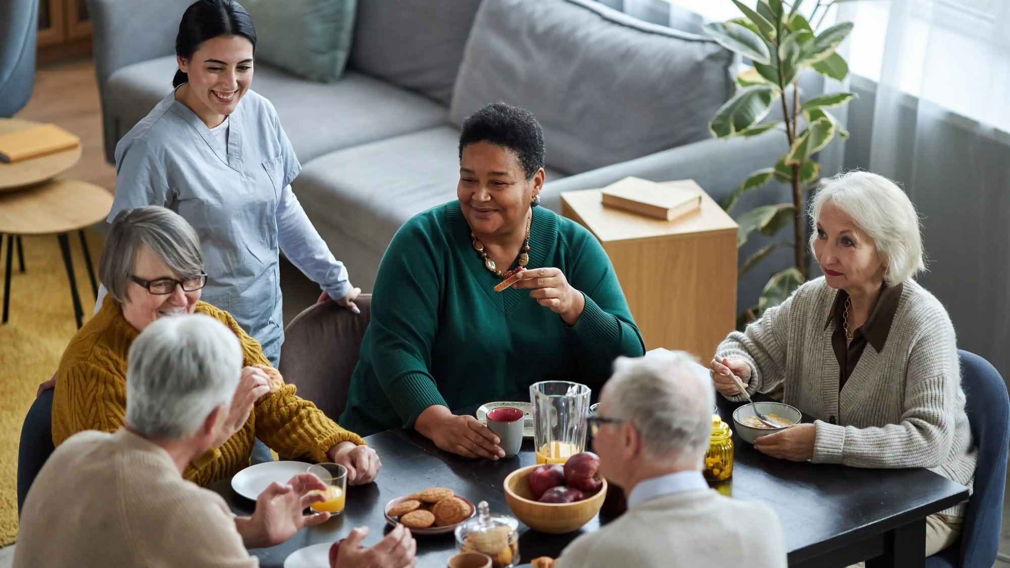 senior-people-sitting-at-table-together-and-smilin-2023-11-27-05-33-46-utc-1