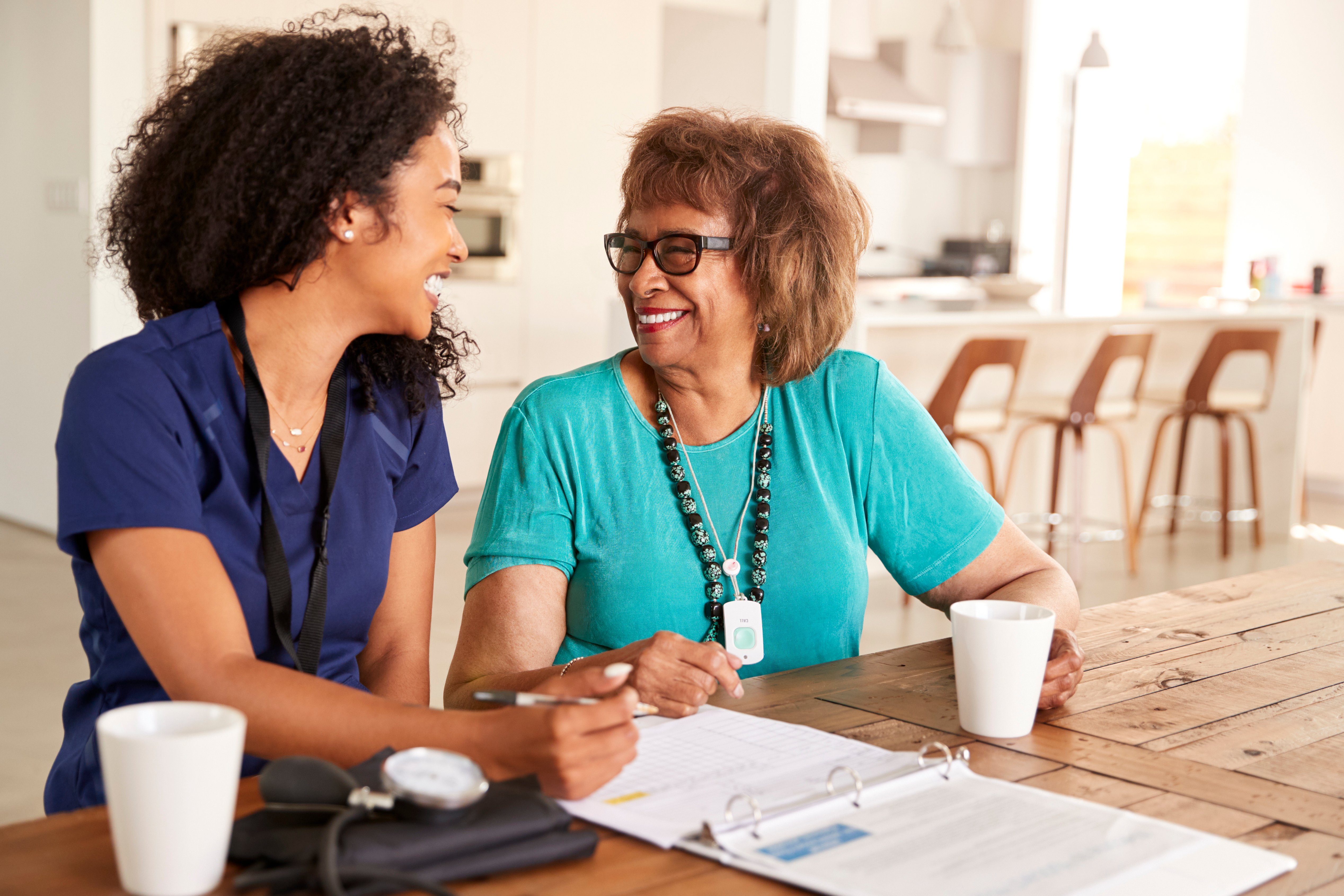 female-healthcare-worker-sitting-at-table-smiling-2023-11-27-05-26-45-utc