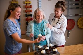Two Therapists Helping Older Patient Bake